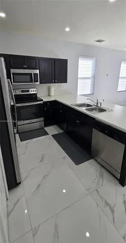 a kitchen with stainless steel appliances a sink and cabinets