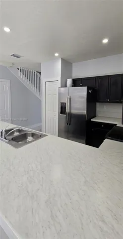 a kitchen with stainless steel appliances kitchen island sink refrigerator and stove