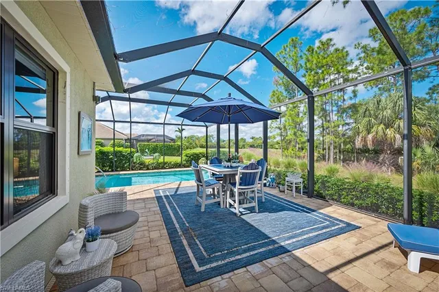 a view of a patio with table and chairs under an umbrella