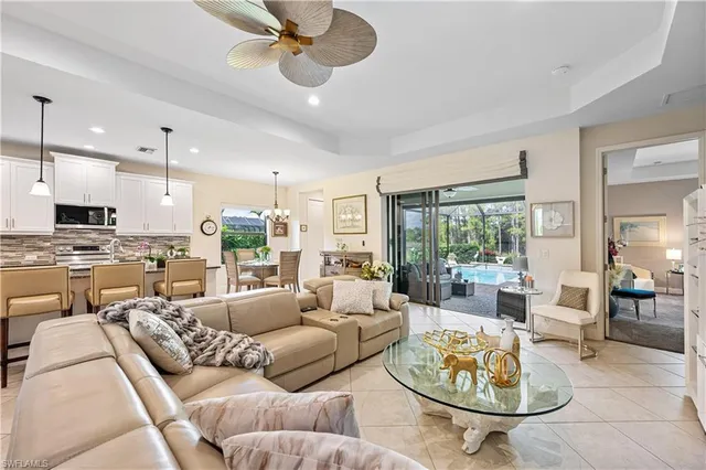 a living room with furniture kitchen view and a large window