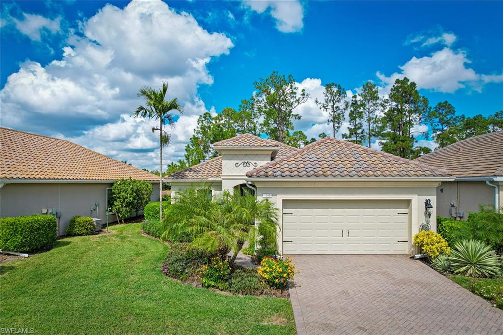 3585 Canopy Circle Naples, FL 34120 - Photo 2 of 46 a front view of a house with a yard garage and outdoor seating