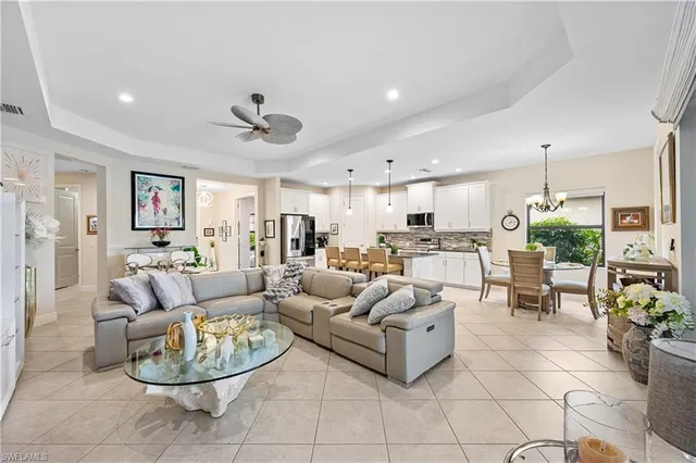 a living room with furniture a fireplace and a chandelier