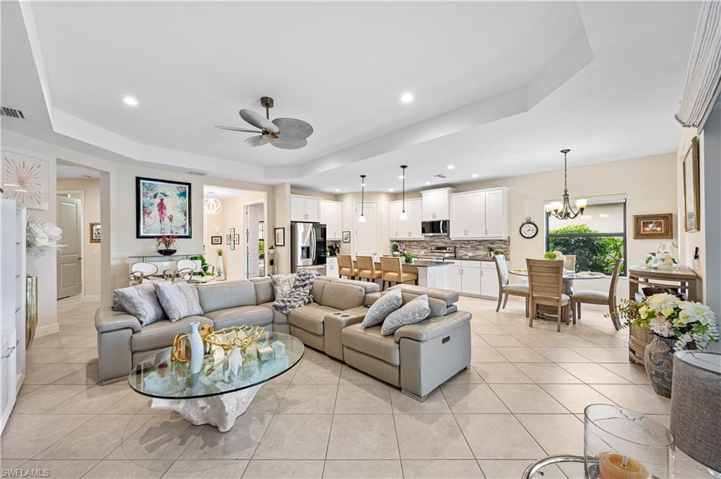 3585 Canopy Circle Naples, FL 34120 - Photo 21 of 46 a living room with furniture a fireplace and a chandelier