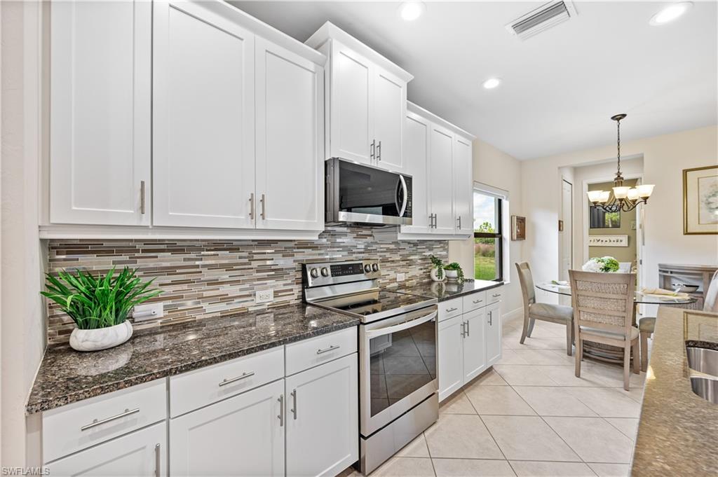 3585 Canopy Circle Naples, FL 34120 - Photo 24 of 46 a kitchen with appliances a sink and cabinets