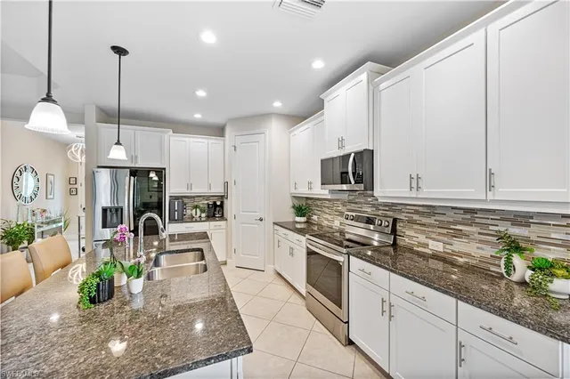 a large kitchen with stainless steel appliances granite countertop a stove a sink and a microwave