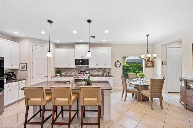 a kitchen with a dining table chairs and cabinets
