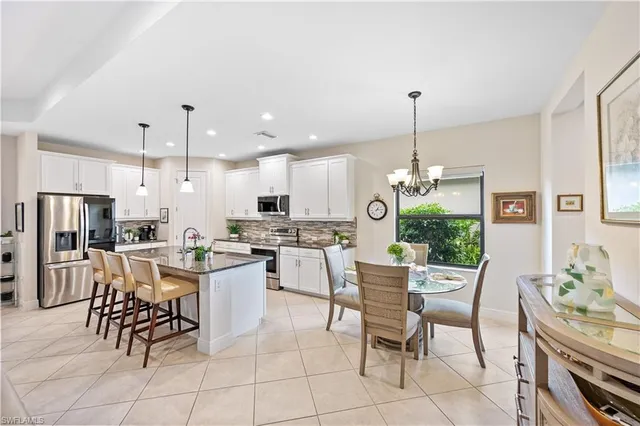 a kitchen with a dining table chairs and a kitchen view