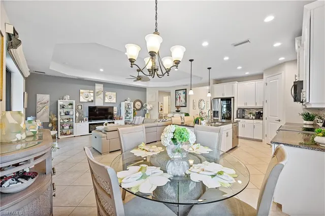 a view of a dining room and livingroom with furniture a rug a fireplace and a chandelier