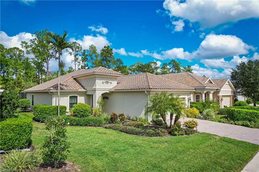 3585 Canopy Circle Naples, FL 34120 - Photo 6 of 46 a front view of a house with a garden