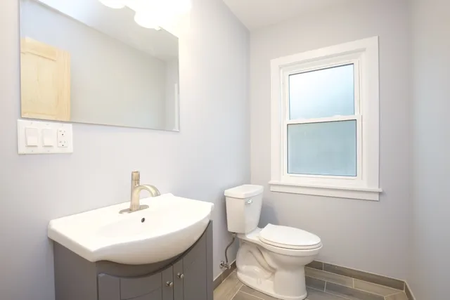 a bathroom with a sink toilet and a mirror
