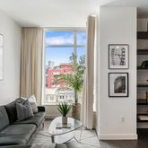 a living room with furniture and a painting on the wall
