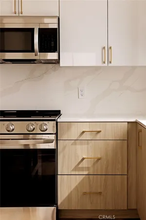 a kitchen with stainless steel appliances a stove microwave and sink