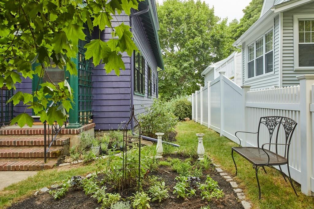 18 Bonad Road Arlington, MA 02476 - Photo 21 of 23 a backyard of a house with table and chairs and potted plants