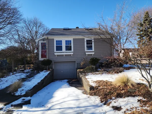 a front view of a house with a yard covered with snow