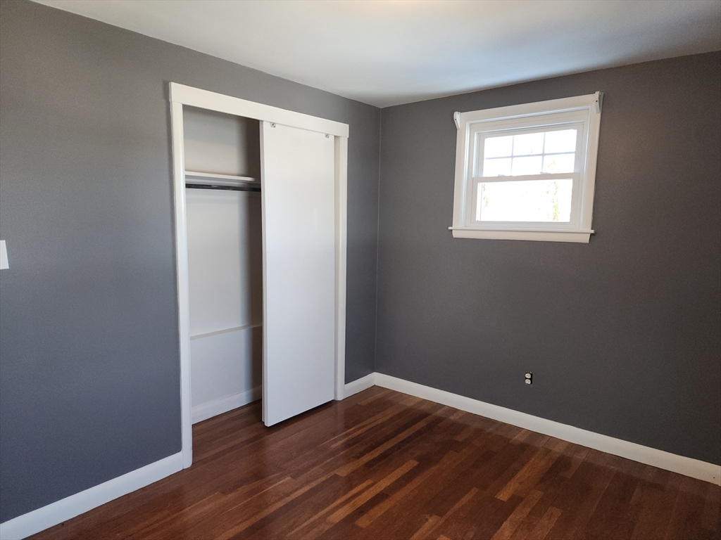 23 Brewster Road Weymouth, MA 02191 - Photo 12 of 21 a view of an empty room with wooden floor and a window