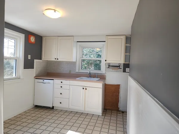 a kitchen with granite countertop white cabinets and white appliances