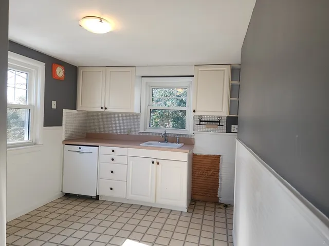 a kitchen with granite countertop white cabinets and white appliances