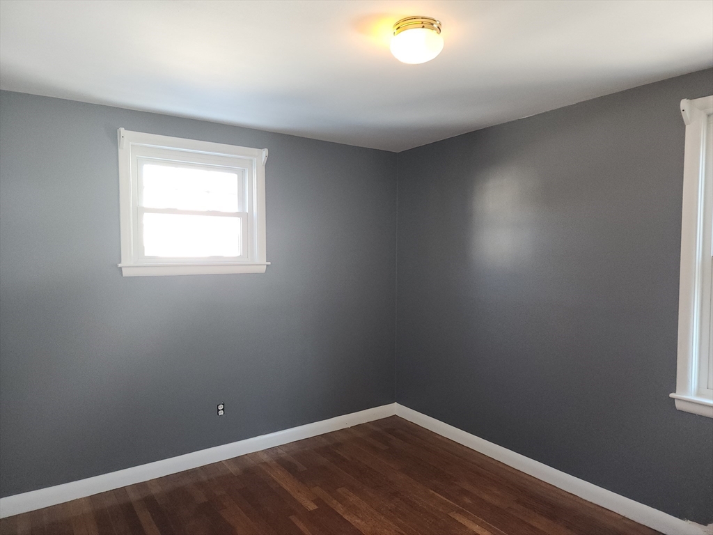 23 Brewster Road Weymouth, MA 02191 - Photo 9 of 21 an empty room with wooden floor and windows