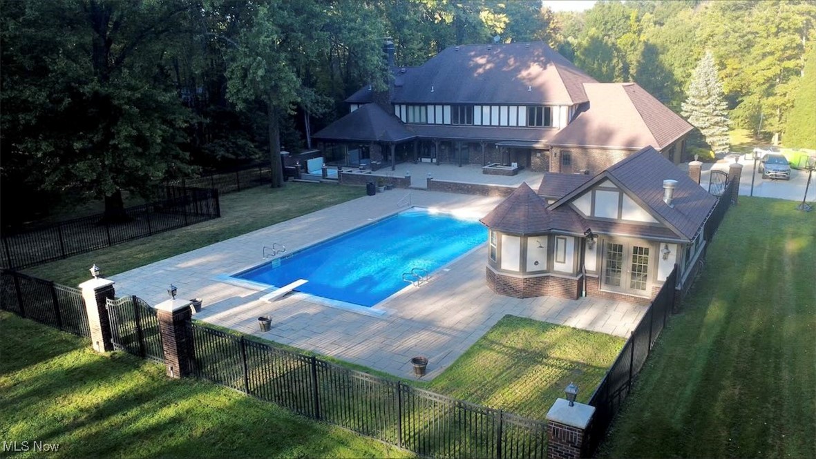 1760 Chartley Road Gates Mills, OH 44040 - Photo 30 of 49 View of swimming pool featuring a patio, a fenced backyard, a balcony, french doors, and a wooded view