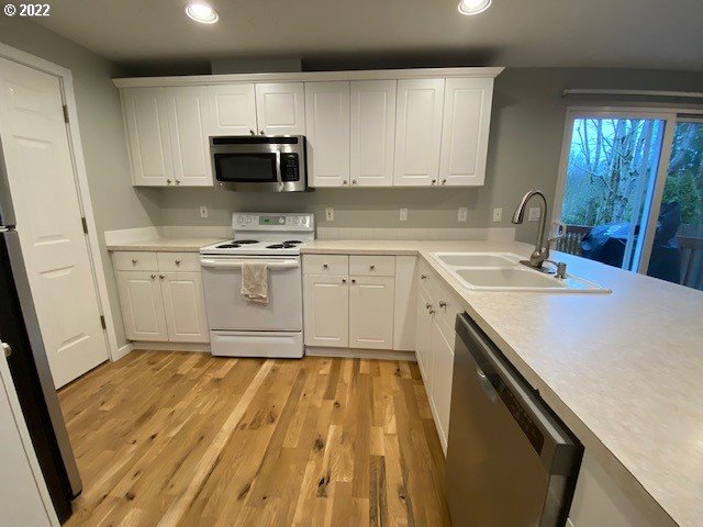 37227 Solso Road Sandy, OR 97055 - Photo 2 of 28 a kitchen with stainless steel appliances a stove a sink and a microwave