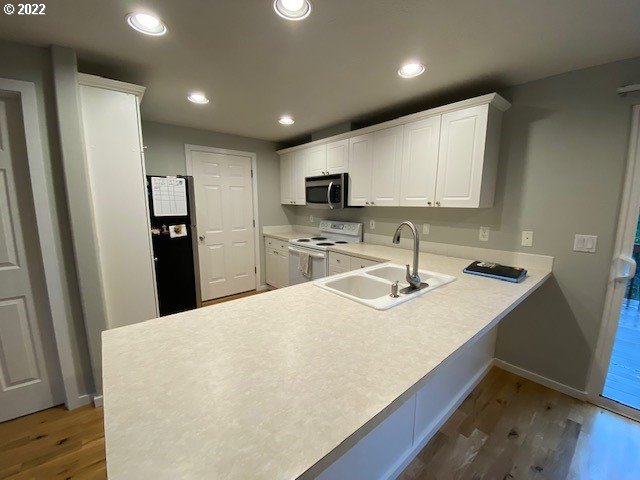 37227 Solso Road Sandy, OR 97055 - Photo 4 of 28 a kitchen with a sink a refrigerator and a stove top oven with wooden floor