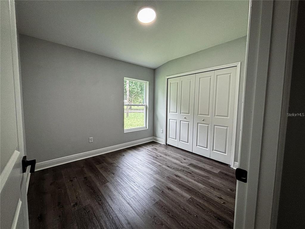 4202 Westminster Road Sebring, FL 33875 - Photo 3 of 8 an empty room with wooden floor and windows