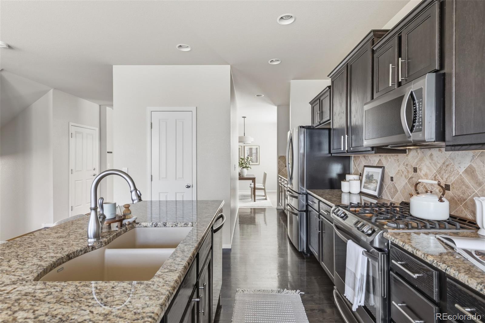 1150 Mircos Street Erie, CO 80516 - Photo 12 of 46 a kitchen with granite countertop a sink stainless steel appliances and cabinets