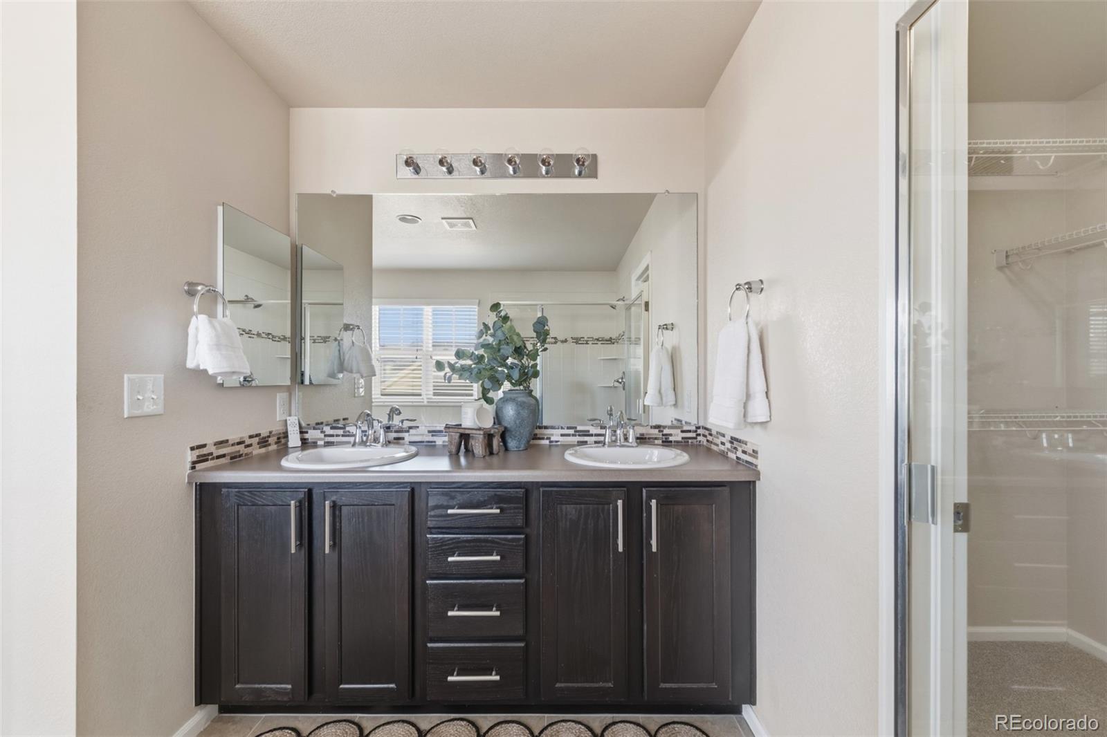 1150 Mircos Street Erie, CO 80516 - Photo 22 of 46 a bathroom with a granite countertop sink a mirror and a shower