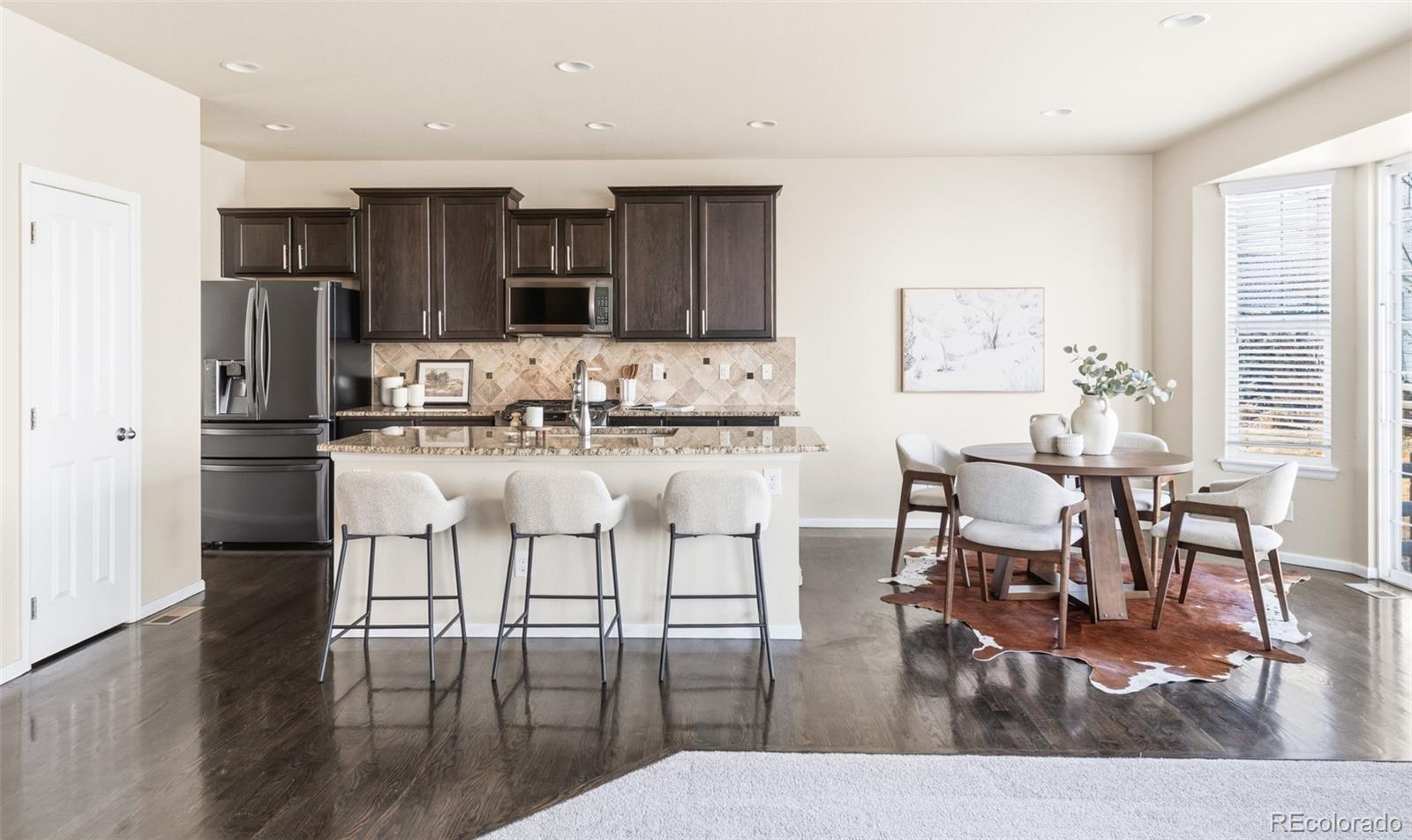 1150 Mircos Street Erie, CO 80516 - Photo 9 of 46 a kitchen with stainless steel appliances kitchen island granite countertop a dining table chairs and granite counter tops