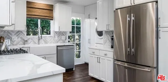 a kitchen with stainless steel appliances a refrigerator sink and cabinets