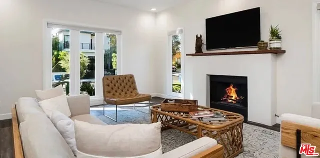a living room with furniture a flat screen tv and a fireplace