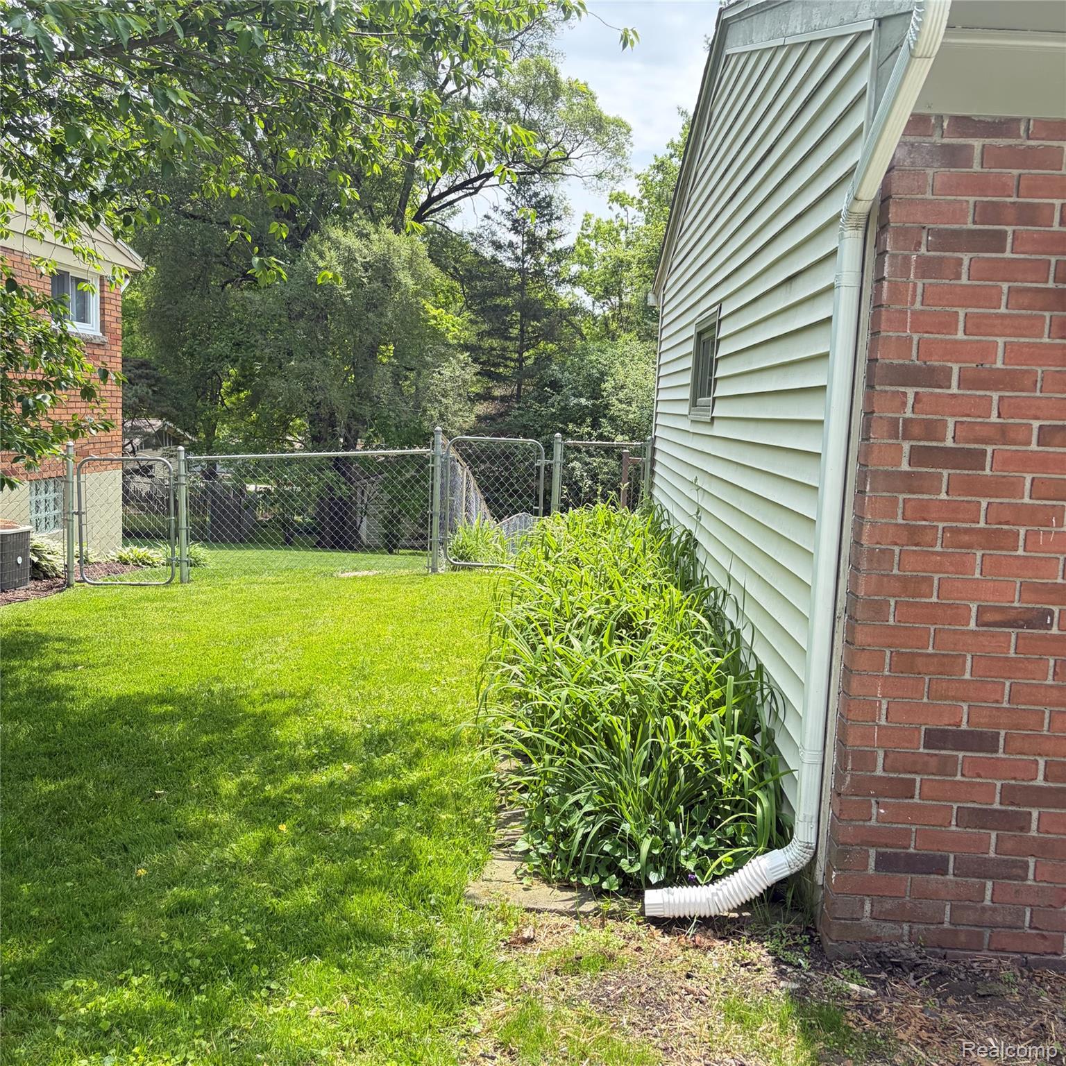1451 Wilshire Road Haslett, MI 48840 - Photo 7 of 42 Exterior siding and brick construction with a fenced yard