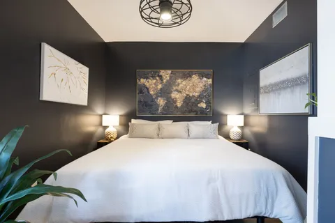a bedroom with a bed and a painting on the wall