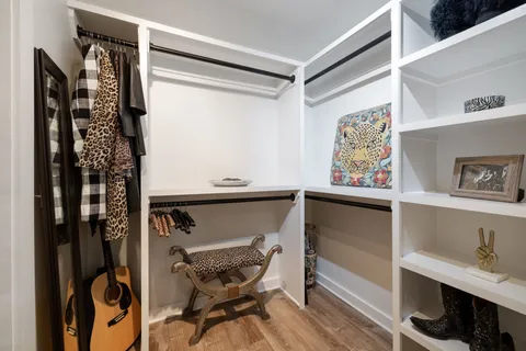 a view of walk in closet with clothes and shoes