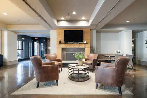 a kitchen with stainless steel appliances granite countertop table chairs and a refrigerator