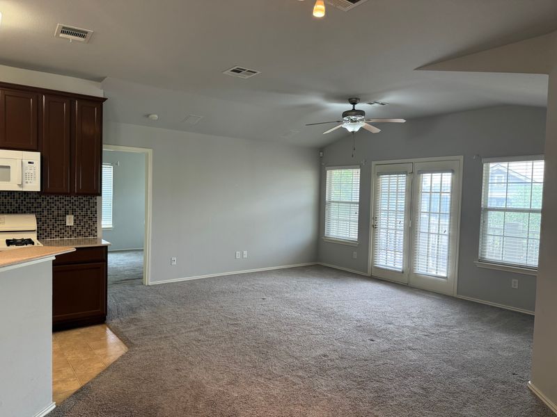 1900 Scofield Ridge Parkway, Unit 4701 Austin, TX 78727 - Photo 6 of 27 An open living area featuring a kitchen pass-through and a pair of glass panel doors leading to the outdoors.