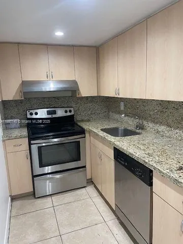 a kitchen with granite countertop a stove and a sink