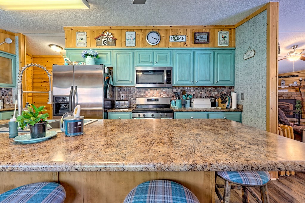 1483 Hilltop Road Murphy, NC 28906 - Photo 44 of 74 a kitchen with stainless steel appliances granite countertop a stove a sink and a dining table