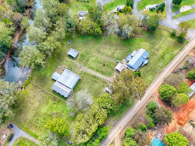 an aerial view of a house with a yard basket ball court and outdoor seating