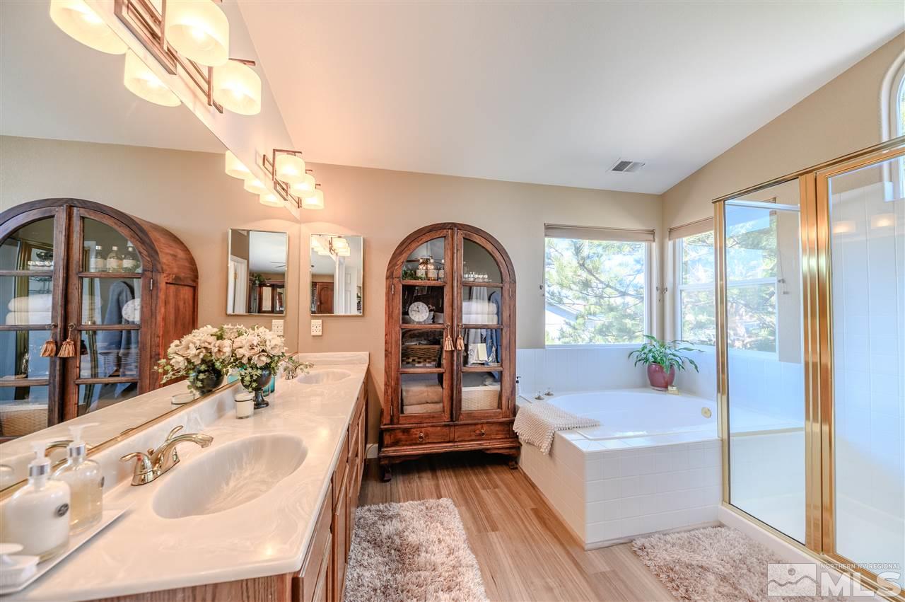 14225 Ghost Rider Drive Reno, NV 89511 - Photo 12 of 24 a spacious bedroom with a large bed and a chandelier