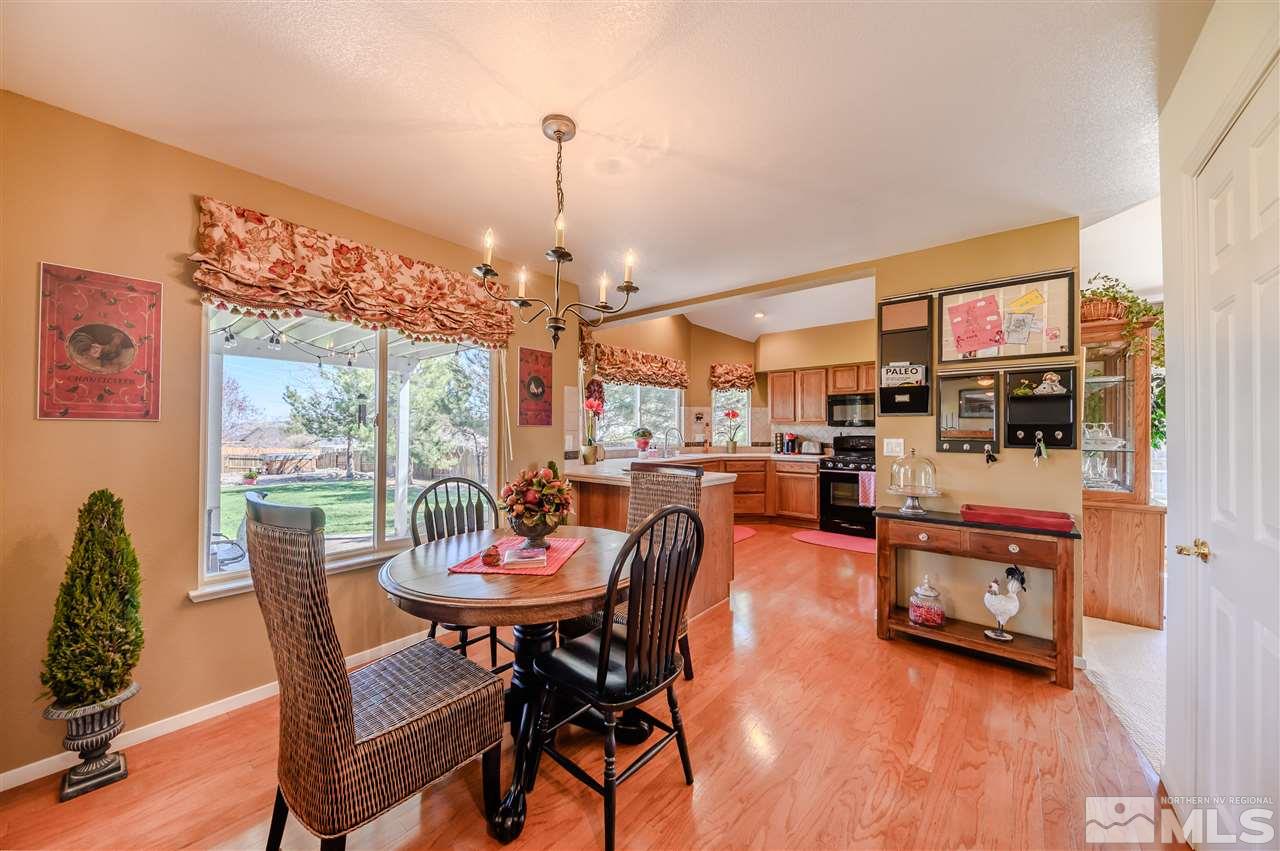14225 Ghost Rider Drive Reno, NV 89511 - Photo 5 of 24 a view of a dining room with furniture a chandelier and wooden floor