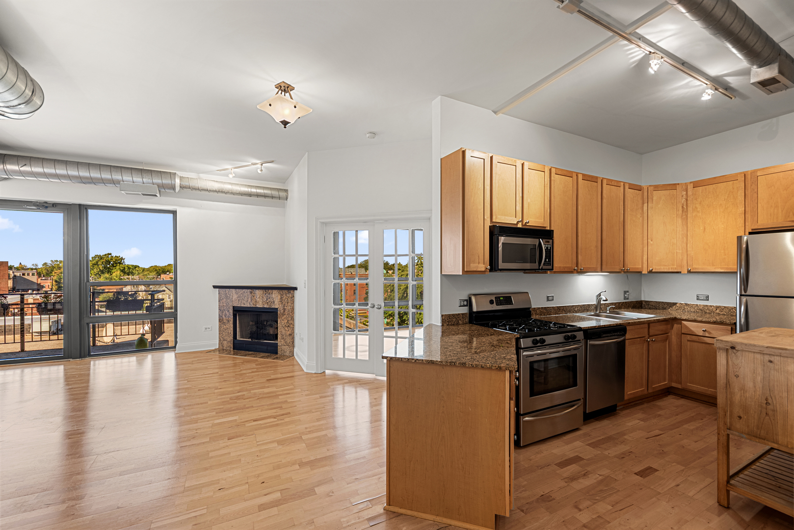 4020 North Damen Avenue, Unit 404 Chicago, IL 60618 - Photo 3 of 17 a kitchen with stainless steel appliances granite countertop a stove top oven a sink dishwasher a dining table and chairs with wooden floor