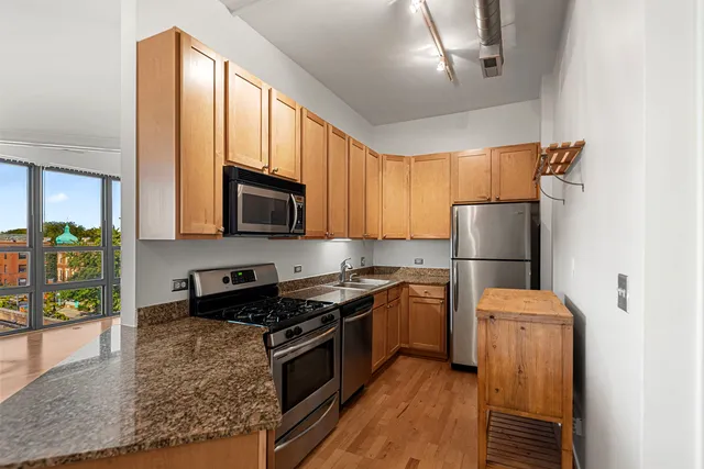a kitchen with stainless steel appliances granite countertop a refrigerator stove and microwave