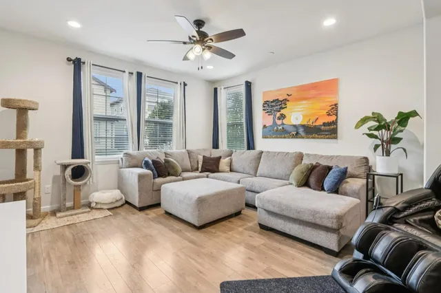 a living room with furniture ceiling fan and a flat screen tv