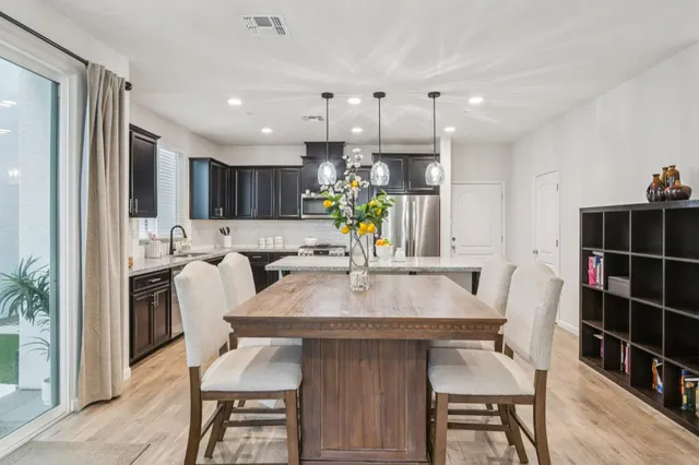 a view of kitchen with dining table chairs cabinets and stainless steel appliances