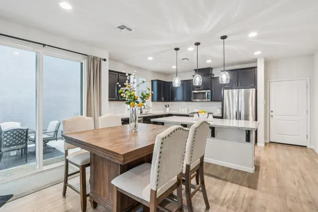 a kitchen with kitchen island a table and chairs in it
