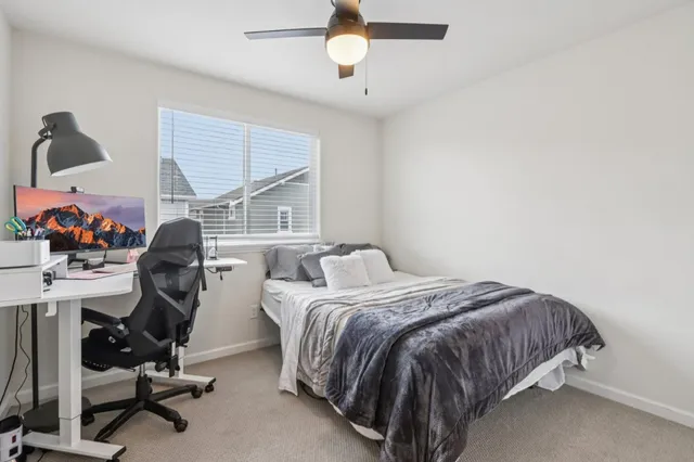 a bedroom with a bed a chair and a large window
