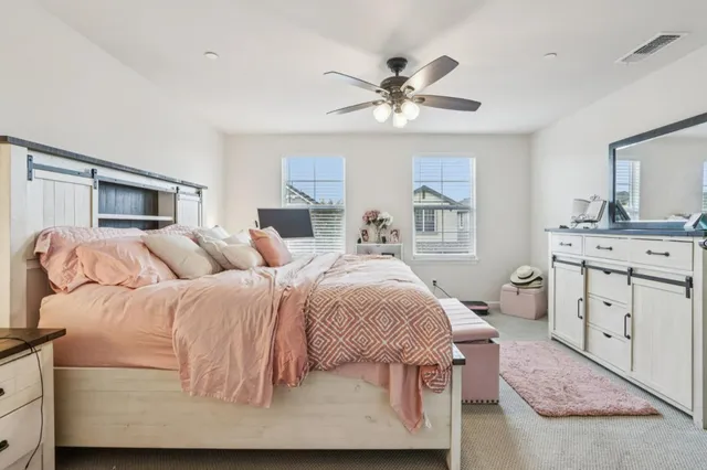 a bedroom with a large bed and a chandelier