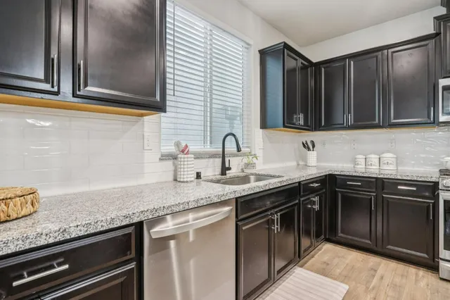 a kitchen with stainless steel appliances granite countertop a sink stove and cabinets
