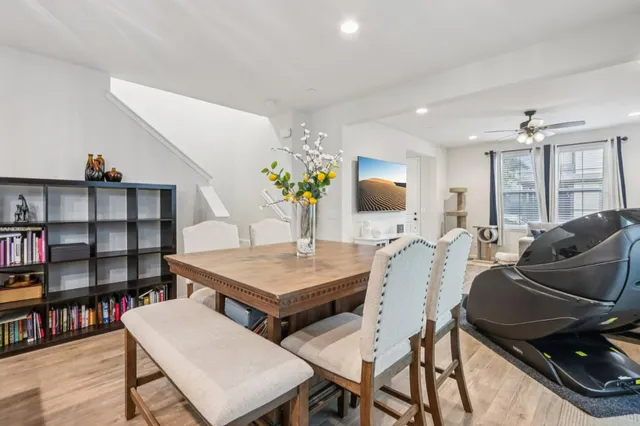 a living room with furniture a bookshelf and a flat screen tv